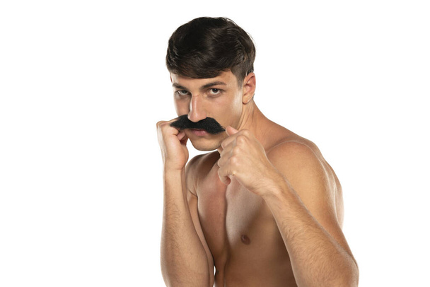 Young shirtless man with moustache in boxing stance on a white studio background - Photo, Image
