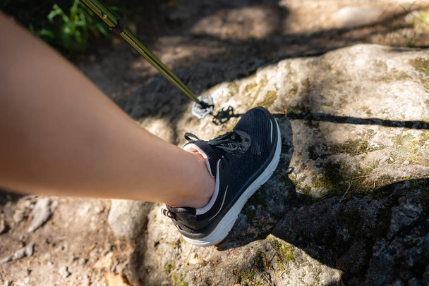 Womans leg hiking along a path of forest stones, Guadarrama, Madrid - Photo, Image