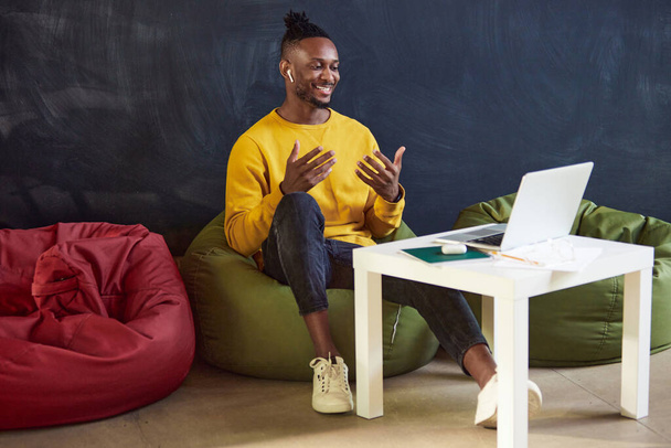 Young african man working remotely online, leading online video call with colleagues, discussing projects, gesturing. Concept of business and education, freelance job, modern lifestyle - Fotó, kép
