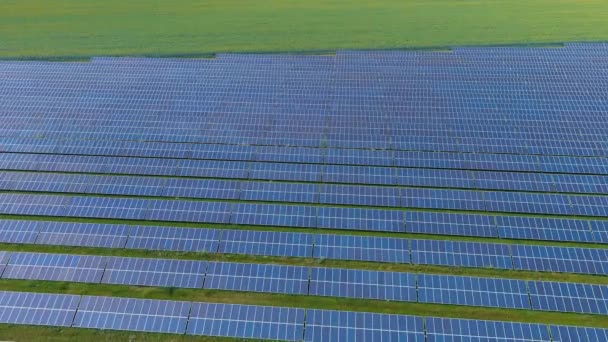 Vista superior de una planta de energía solar en el campo (cámara se mueve de derecha a izquierda). Ecología. Energía verde alternativa. Cero emisiones. Drone. Vista aérea - Imágenes, Vídeo