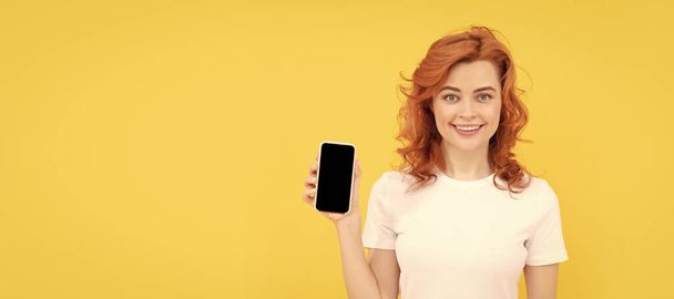 Nainen eristetty kasvot muotokuva, banneri mallintaa kopioi tilaa. hymyilevä nainen chattailuun älypuhelimeen tai tehdä verkko-ostoksia keltaisella taustalla, viestintä - Valokuva, kuva