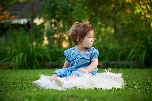 Adorabile ragazza sull'erba in giardino. Ritratto di chiusura. Ragazzina felice nel paesaggio estivo. Dolce bambino all'aperto. - Foto, immagini
