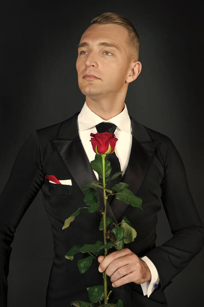 A szmokingos férfi képe Valentin-napon. szmokingos férfi Valentin-napon. A szmokingos férfi Valentin-rózsát tart. szerelem alkalom Valentin szmoking férfi. - Fotó, kép
