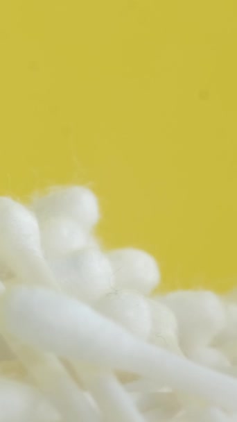 hisopos giratorios de algodón sobre un fondo cromado amarillo. Productos de higiene. Vídeo vertical. - Imágenes, Vídeo