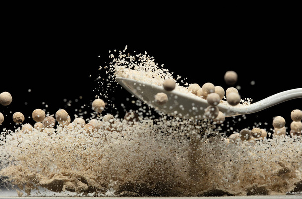 White Pepper seeds fly explosion, white Pepper mix powder float explode, abstract cloud fly. Peppercorn mix powder splash throwing in Air. Black background Isolated selective focus blur - Photo, Image