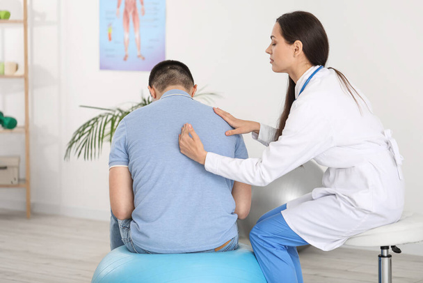 Femme médecin vérifier la posture du jeune homme à la clinique - Photo, image