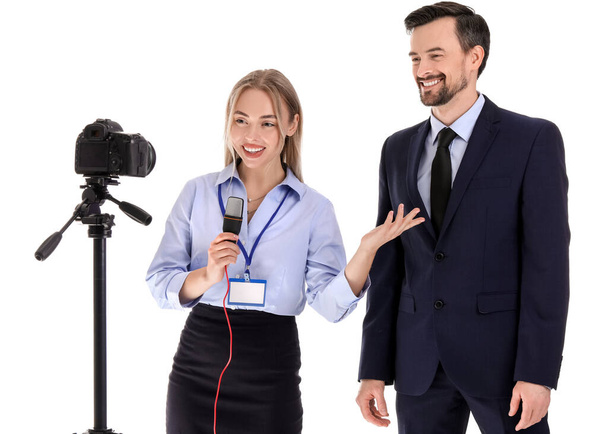 白い背景でビジネスマンとのインタビューを持ってマイクを持つ女性ジャーナリスト - 写真・画像