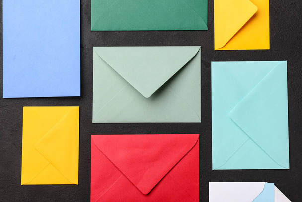 Composition with colorful envelopes on dark background, closeup - Photo, Image