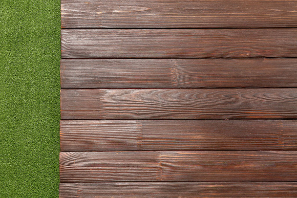 Dark wooden table against green grass background, closeup - Фото, изображение