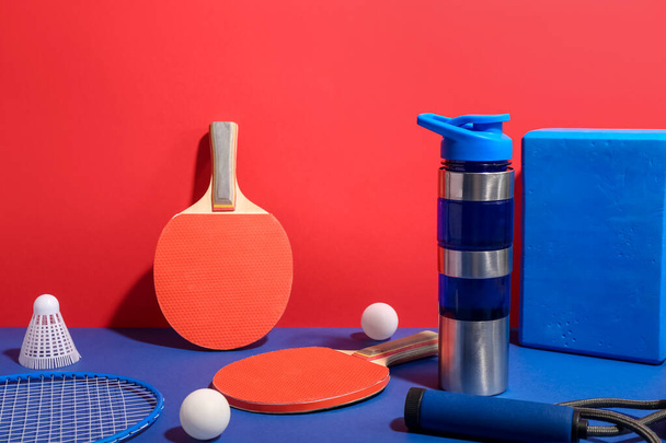 Pullo vettä ja erilaisia urheiluvälineitä värillä taustalla - Valokuva, kuva
