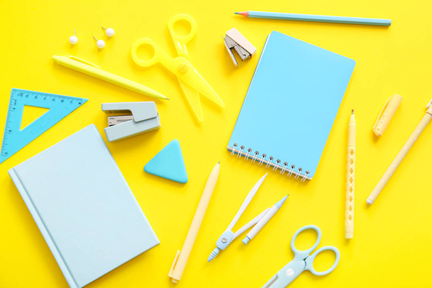 Diferentes artigos de papelaria escolar e cadernos em fundo amarelo - Foto, Imagem
