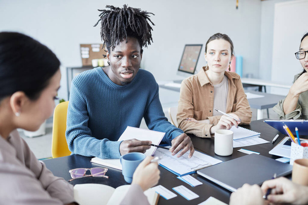 Retrato de jovem negro em discussão de grupo no seminário de Inglês no escritório, espaço de cópia - Foto, Imagem