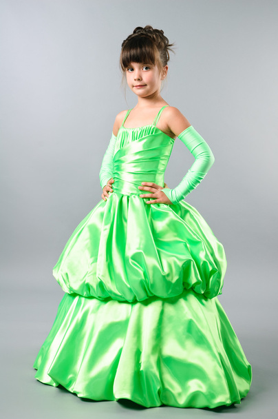 Cute little girl posing on studio neutral background in gorgeous green gown - Foto, Imagem