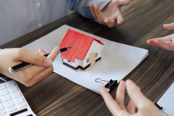 Immobilienmakler und Bauherr sprechen vor Vertragsunterzeichnung über Immobilienversicherung und Sicherheitskonzept für Haus zu Bauherr.. - Foto, Bild