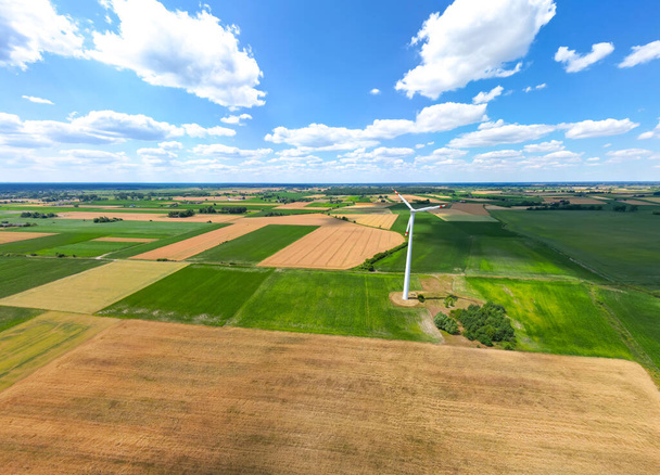 Vista aérea da poderosa fazenda de turbinas eólicas para a produção de energia no belo céu nublado no planalto. Turbinas eólicas geradoras de energia renovável limpa para o desenvolvimento sustentável. - Foto, Imagem