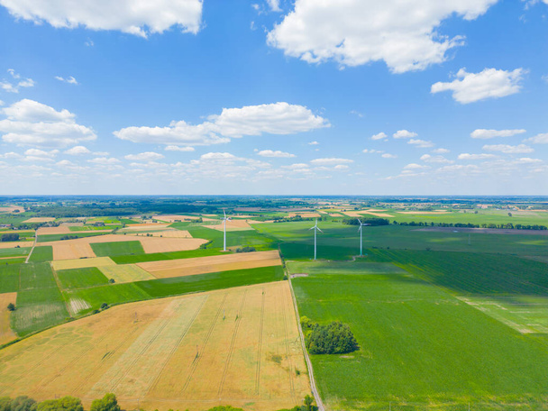Luftaufnahme eines leistungsstarken Windturbinenparks zur Energiegewinnung bei schönem bewölkten Himmel im Hochland. Windkraftanlagen zur Erzeugung sauberer erneuerbarer Energien für eine nachhaltige Entwicklung. - Foto, Bild