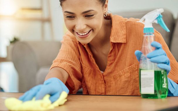 Спрей, жінка і посмішка для прибирання столу, меблів і домашнього господарства. Жіночий очищувач протирає поверхню тканиною, пляшкою хімічного продукту та дезінфекцією пилу, бактерій та бруду. - Фото, зображення