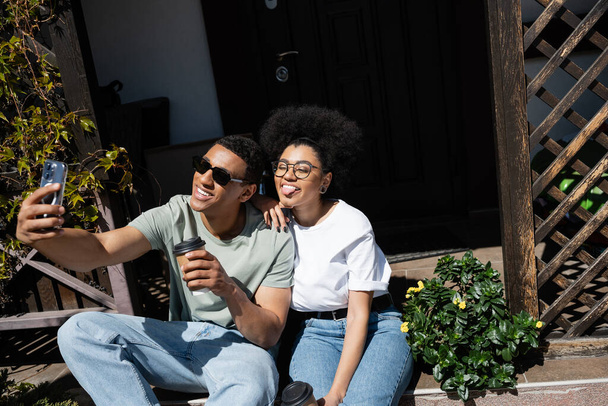 afro-amerikai pár kávé menni selfie okostelefon a verandán az új ház - Fotó, kép