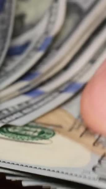 Vídeo macro del conteo de billetes de cien dólares por manos masculinas. Primer plano de los billetes de 100 dólares que se cuentan. Concepto de negocio, finanzas. Vídeo vertical - Imágenes, Vídeo
