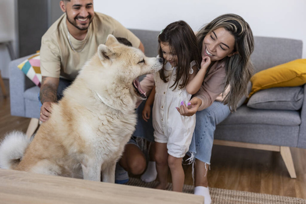 hispanische Familie auf der Couch mit ihrem gähnenden Hund - Foto, Bild