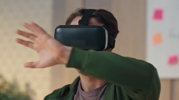 Zbliżenie startuper przesuwając metawersum w biurze. Inteligentny VR okulary człowiek deweloper dotykając niewidzialny interfejs testowania nowej gry 3d. Spokojny twórca wykorzystujący wirtualny zestaw słuchawkowy symulacyjny zanurzający futurystyczne dane - Materiał filmowy, wideo