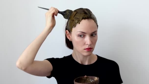 Gyönyörű nő festi a haját egy gyógynövény keveréke henna és basma, hogy készítsen egy barna színű. - Felvétel, videó