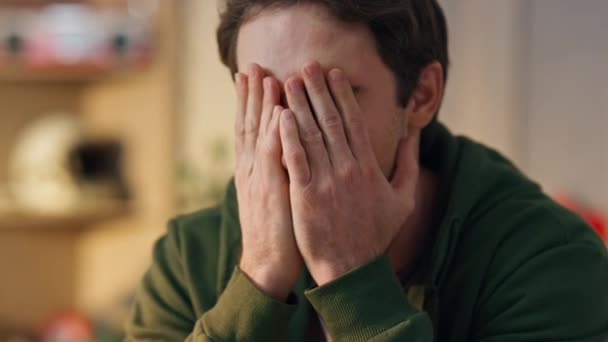 Disappointed man covering face palm thinking in home office closeup. Stressed creator worried project fault working at modern interior. Tired overworked designer rubbing eyes with sad emotions at work - Footage, Video