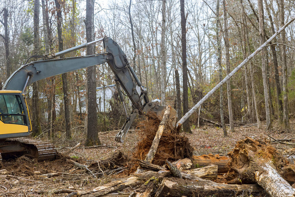 Excavator is being used by worker to clear land for house construction. - Photo, Image