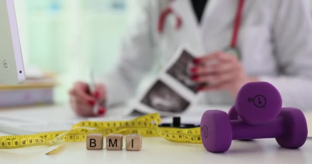 Nastro per misurare i manubri e la parola BMI nel medico. Rapporto tra altezza e peso della persona calcolo della norma e gravidanza - Filmati, video