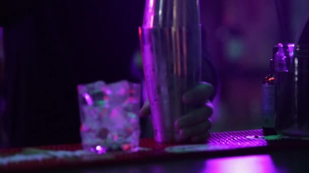 4K Cantinero profesional masculino que vierte licor azul mezclado bebida de cóctel de coctelera en vaso de chupito en el mostrador del bar en la discoteca. Mixólogo barman haciendo bebida alcohólica sirviendo al cliente - Metraje, vídeo