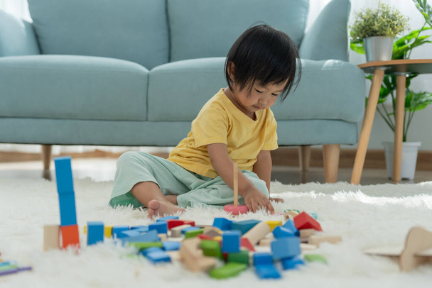 Glückliche asiatische Kinder spielen und lernen Spielzeugblöcke. Familie ist glücklich und aufgeregt im Haus. Tochter, die Spaß daran hat, Zeit zu verbringen, Aktivität, Entwicklung, IQ, EQ, Meditation, Gehirn, Muskeln, grundlegende Fähigkeiten - Foto, Bild