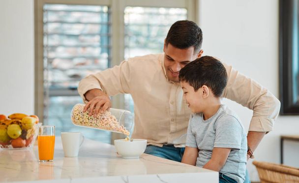 Ontbijt, ochtend en ontbijtgranen met vader en zoon aan tafel voor liefde, eten en steun. Gelukkig, ontspannen en gezond met man en kind eten in gezinswoning voor voeding, helpen en geluk samen. - Foto, afbeelding