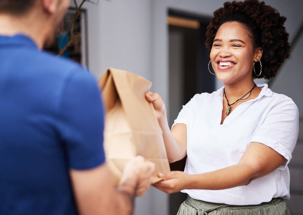 Paket, Zusteller und eine Frau vor der Tür mit einem Lächeln und Papiertüte für E-Commerce und Versand. Logistik, Online-Shopping und Fracht- oder Kurierdienste, die einem zufriedenen Kunden eine Fast-Food-Bestellung geben. - Foto, Bild