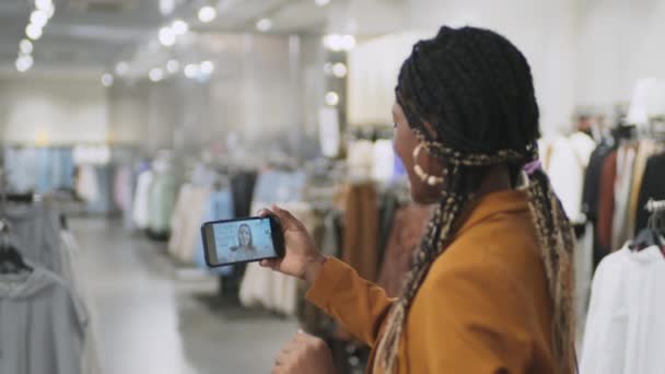 Hátsó nézet afro-amerikai nő online beszél barátjával okostelefonon vásárlás közben - Felvétel, videó