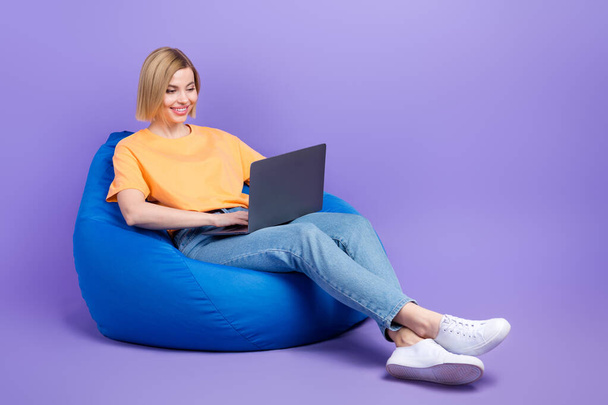 Full length body photo of young businesswoman lying pouf comfortable with netbook create code program isolated on purple color background. - Φωτογραφία, εικόνα