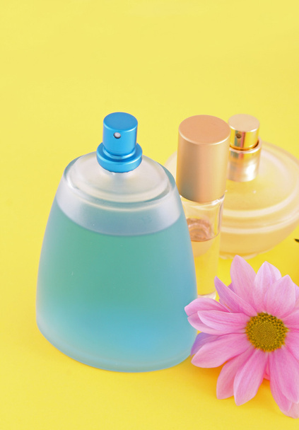 Bottle of perfume and camomile on yellow background - Foto, afbeelding