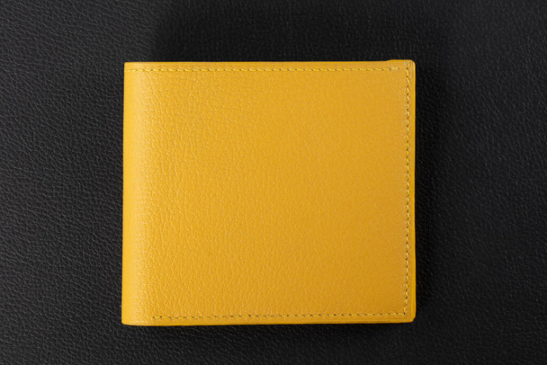 Kožené výrobky. Držák vizitky peněženky ze žluté kůže na černém pozadí. - Fotografie, Obrázek
