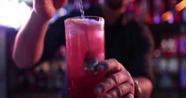 4K profesyonel barmen kokteyl bardağından barın tezgahına karışık mavi likör kokteyli dolduruyor. Barmen müşteriye alkol servisi yapıyor. - Video, Çekim