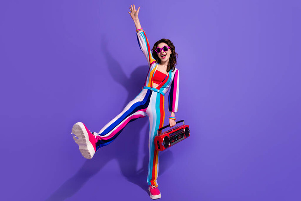 Photo of positive cool girl dancing active energetic with boom box pop music isolated on vivid color background. - Foto, afbeelding