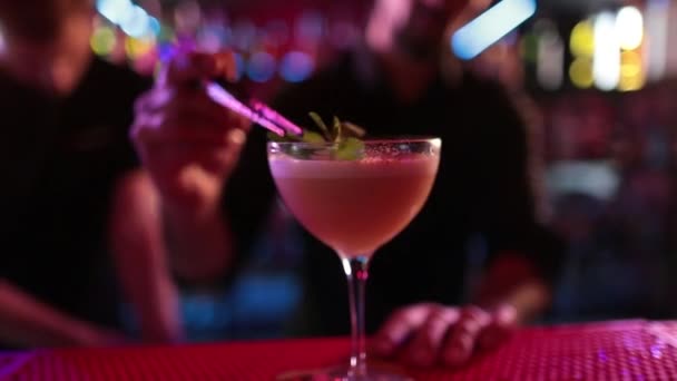 4K Professional barista maschile versando cocktail cocktail di liquori blu misti da shaker cocktail in bicchierino sul bancone del bar al nightclub. Mixologo barman fare bevanda alcolica che serve al cliente - Filmati, video