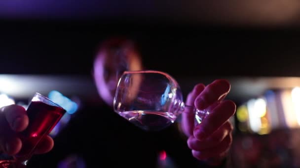 4K profesyonel barmen kokteyl bardağından barın tezgahına karışık mavi likör kokteyli dolduruyor. Barmen müşteriye alkol servisi yapıyor. - Video, Çekim