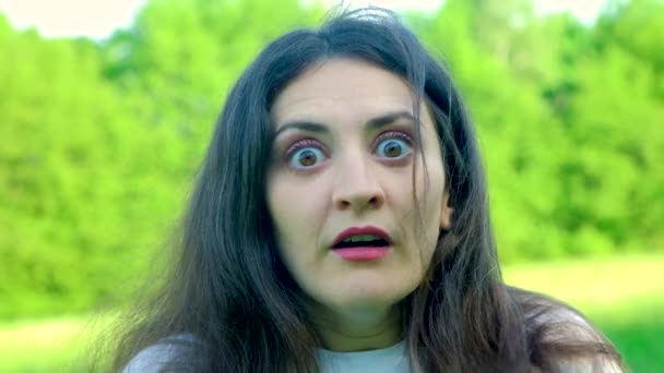 Eine Frau blickt verängstigt in die Kamera, Augen und Mund weit aufgerissen - Filmmaterial, Video
