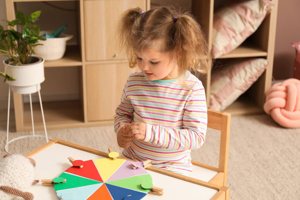 Menina bonito jogando jogo de correspondência com clothespins em casa - Foto, Imagem