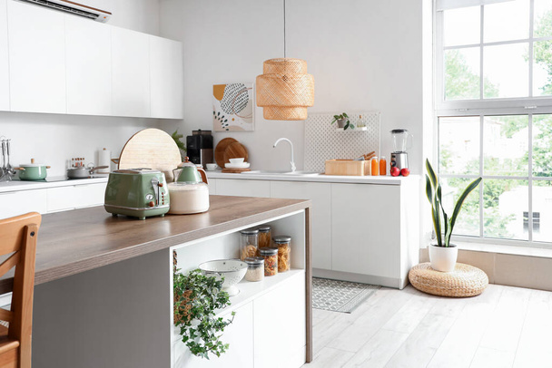 Interior de cocina ligera con electrodomésticos modernos en mesa de madera - Foto, Imagen