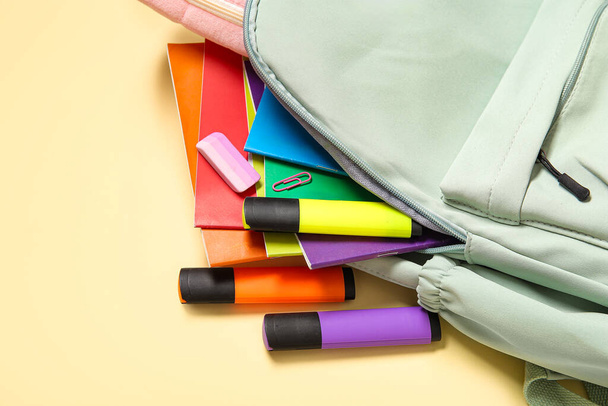 Zelený školní batoh s různou šablonou na světle žlutém pozadí - Fotografie, Obrázek