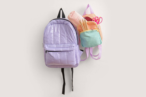 Plecaki szkolne kolorowe z papeterią na jasnym tle - Zdjęcie, obraz
