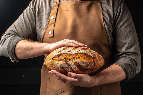 αρσενικά χέρια κρατώντας ψωμί. σπιτικό γλυκό φούρνου. Υγιεινή διατροφή. τόπος για κείμενο. - Φωτογραφία, εικόνα