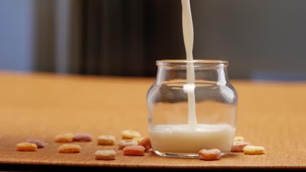 Text zmiňuje různé scénáře týkající se mléka, jako je například nalití do sklenice, smíchání s mandlemi a přidání arašídů. K dispozici je také sklenice mléka se nalévá do sklenice, stejně jako s arašídy umístěné na stole - Záběry, video