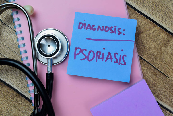 Concept van Diagnose Psoriasis schrijven op plakkerige noten geïsoleerd op houten tafel. - Foto, afbeelding