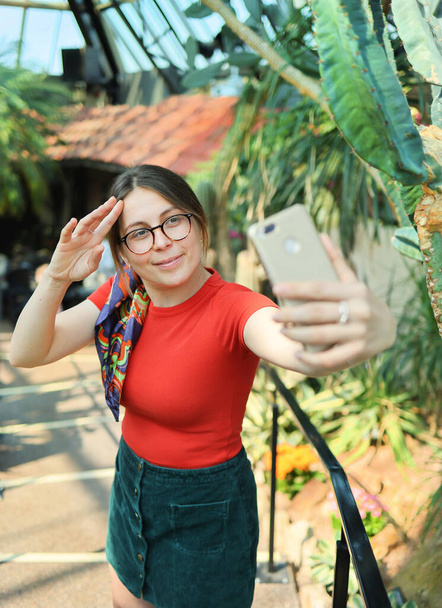 Young woman tourist make selfie in a botanical garden - Фото, изображение